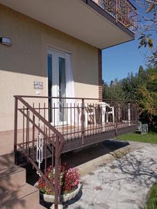 a wooden deck on the side of a house with flowers at Alloggio San Francesco in Peschiera del Garda