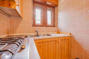 een keuken met een spoelbak en een fornuis bij Casa Verocai - Mountain View Terrace & Parking in Cortina dʼAmpezzo +38 foto's