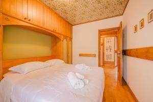 een slaapkamer met een bed met handdoeken erop bij Casa Verocai - Mountain View Terrace & Parking in Cortina dʼAmpezzo