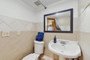 a bathroom with a sink and a toilet and a mirror at Hickory Hideaway on the Lake in Lake Ozark +7 photos