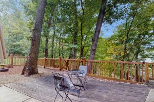 two chairs and a table on a wooden deck at Hickory Hideaway on the Lake in Lake Ozark
