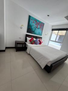 a bedroom with a large bed with a painting on the wall at Villa Rooftop in Ban Saiyuan (1)