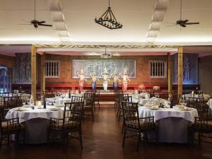 a banquet hall with tables and dancers on the stage at Raffles Grand Hotel d'Angkor in Siem Reap