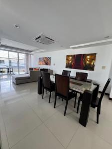 a dining room with a table and chairs and a couch at Villa Rooftop in Ban Saiyuan (1)