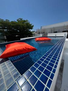 a pool with two red umbrellas on top of it at Villa Rooftop in Ban Saiyuan (1) +5 photos