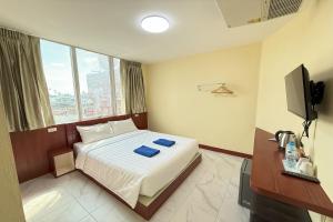 a hotel room with a bed and a television at Scala Hostel in Bangkok