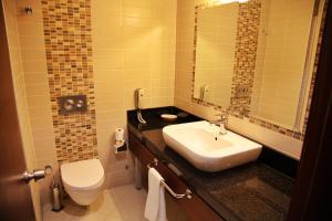 a bathroom with a sink and a toilet and a mirror at Yücelen Otel Muğla in Gülağzı +34 photos