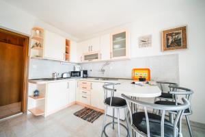 a kitchen with white cabinets and a table and chairs at Anna in Hvar * Mittel-Dalmatien in Hvar +49 photos