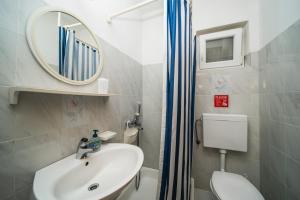 a bathroom with a sink and a mirror and a toilet at Anna in Hvar * Mittel-Dalmatien in Hvar