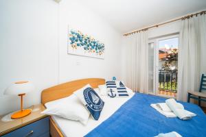 a bedroom with a blue and white bed and a window at Anna in Hvar * Mittel-Dalmatien in Hvar