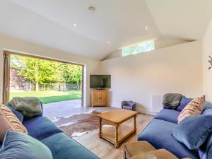 HowellにあるRed Brick Barn - Uk39916の青いソファとテーブルのあるリビングルーム