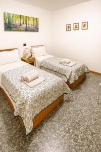 a room with two beds with towels on them at Melannie's Apartment in Bergamo
