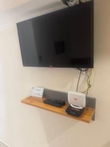 Un televisor de pantalla plana colgado en una pared con un estante. en Mostar Dream, en Mostar
