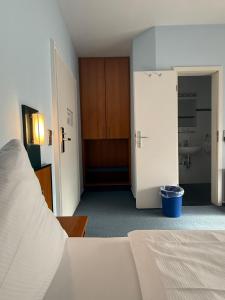 a bedroom with a bed and a bathroom with a sink at SVG Hotel Diversi in Ludwigshafen am Rhein +5 photos