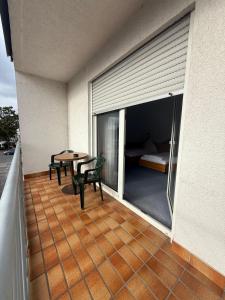 a balcony with a table and chairs and a bedroom at SVG Hotel Diversi in Ludwigshafen am Rhein