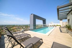 a balcony with chairs and a swimming pool on a building at Departamento de lujo en zona Carmelitas in Asuncion