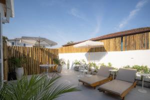 a patio with chairs and tables and an umbrella at Olisa Praia Hotel in Maresias