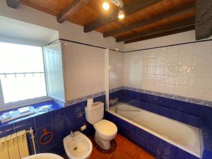 a bathroom with a toilet and a tub and a sink at casita en Fresinidiello para 4 personas  +47 photos