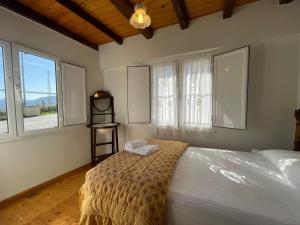 a bedroom with a bed with a blanket and windows at casita en Fresinidiello para 4 personas 
