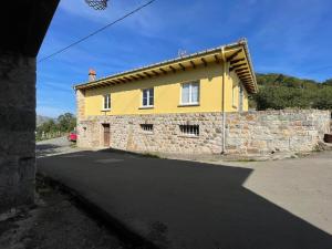 a yellow house with a stone wall at casita en Fresinidiello para 4 personas 