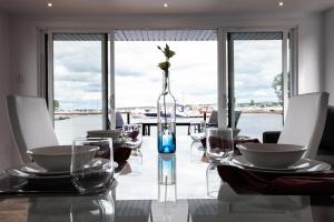 a glass table with a vase with a flower in it at Yacht Club de Trois-Rivières 1 - Maison flottante in Trois-Rivières