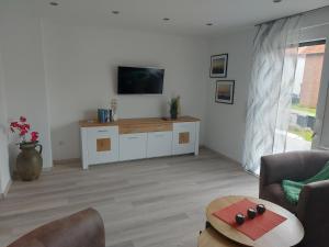 a living room with a tv on a white wall at Ferienwohnung Bergstraße in Extertal
