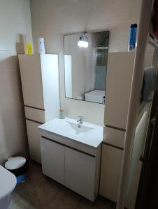 une salle de bain avec un lavabo et un miroir dans l'établissement Casa da Familia Pereira, à Corroios