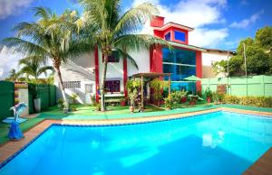 a house with a swimming pool in front of a house at Pousada Mar dos Sonhos in Paripueira