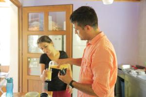 a man and a woman standing in a kitchen preparing a drink at KiDRAK OTEL MONTENEGRO-1 in Faralya