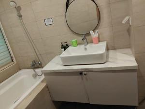 a bathroom with a sink and a mirror and a tub at Lemon Apartment Quy Nhơn in Quy Nhon