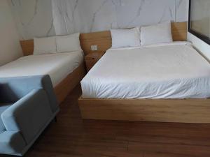 a bedroom with two beds and a couch in it at Lemon Apartment Quy Nhơn in Quy Nhon