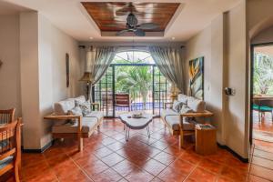 a living room with a couch and a table at Casa Mimosa Poolside in Playa Flamingo