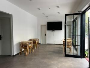 a room with tables and chairs and a flat screen tv at Ranveli Dhigurah in Dhigurah