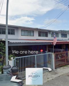 a sign that says we are here in front of a house at Johariza Homestay Sepanggar in Kota Kinabalu