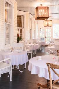 a restaurant with white tables and chairs and a chandelier at The Edenton Collection-The Granville Queen Inn in Edenton +24 photos