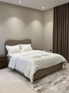 ein Schlafzimmer mit einem großen Bett mit weißer Bettwäsche in der Unterkunft Two Bedroom Luxury Apartment in Dschidda