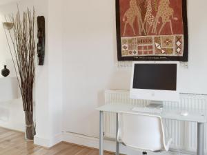 ein weißer Schreibtisch mit einem Computer darüber in der Unterkunft Alices Cottage in Stepaside