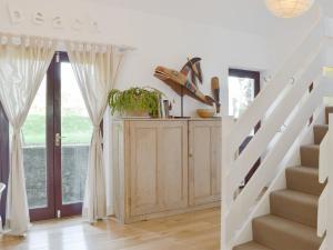 eine Treppe in einem Haus mit weißen Wänden und weißen Vorhängen in der Unterkunft Alices Cottage in Stepaside