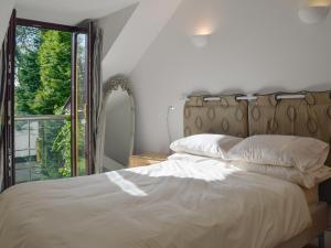 ein Schlafzimmer mit einem Bett mit einem großen Fenster in der Unterkunft Alices Cottage in Stepaside