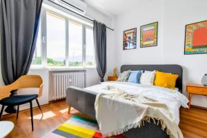 a bedroom with a bed and a chair and windows at Super Fresh! 3bdr Apartment In Sofia Center's Artistic Area in Sofia