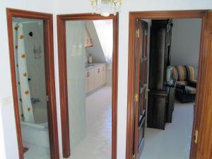 two doors to a bathroom with a shower and a sink at Apartamentos Playa Monte Pindo - Lobeira do Mar in O Pindo
