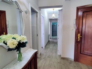 a hallway with a vase of flowers on a counter at Apartamentos Playa Monte Pindo - Morada do Camiño in Cee +19 photos