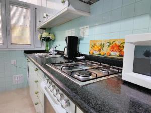 a kitchen with a stove and a microwave at Apartamentos Playa Monte Pindo - Morada do Camiño in Cee