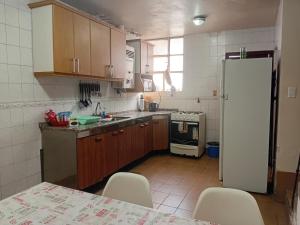 a kitchen with wooden cabinets and a white refrigerator at Casa Centro Santiago in Santiago del Estero