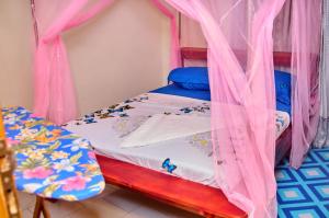 a bedroom with a bunk bed with pink curtains at VICTOR & VICTORY GUEST HOUSE DAMAS-RAIL OBOBOGO Source in Yaoundé
