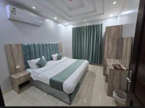 a bedroom with a large bed and a green curtain at دار الكيان - Dar Al-Kayan in Jeddah +10 photos