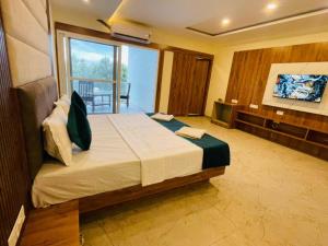 a bedroom with a large bed with a large window at Blue Lagoon Inn Resort in Hosa Kannambādi