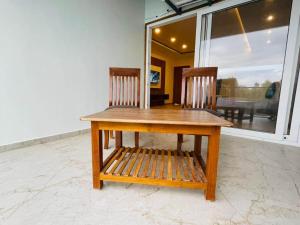 a wooden table and two chairs sitting in a room at Blue Lagoon Inn Resort in Hosa Kannambādi