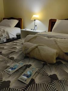 Un dormitorio con dos camas con toallas en la cama. en Casa Centro Santiago, en Santiago del Estero