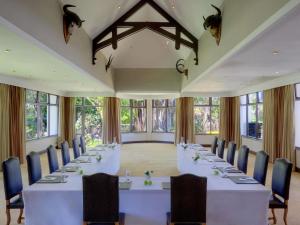a large room with tables and chairs and windows at Fairmont Mount Kenya Safari Club in Nanyuki +119 photos